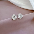 Gros plan de boucles d'oreilles rondes argentées avec cristaux sur du tissu de soie - Style Résistant à la Décoloration / Argent (Q112)