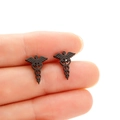 Macro shot of black stainless steel stud earrings featuring the medical Caduceus symbol - Black