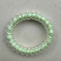 Lucky four-leaf clover spiral hair tie in light green and white polka dot design - Green Core
