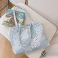 Detail van een blauw-wit gewatteerde shopper met bloemenpatroon op een stoel - Blauw geruit bloemmotief