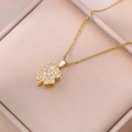 Detailed close-up of a gold rotating clover pendant with shimmering pavé crystal accents - Rotating Heart Necklace / Gold