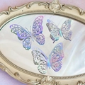 Detailed view of hollow laser butterfly decorations on a vintage mirror surface - Style 2 / Set of 12 / Holographic Silver