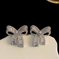 Sparkling silver bow knot earrings with cubic zirconia stones on white ceramic tray - Silver (Silver Pin)