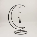 Minimalist moon-shaped black iron display stand with a hanging crystal pendant necklace - Moon Pendulum Stand