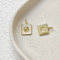 Détail macro de pendentifs carrés plaqués or avec incrustations florales blanches - Rose en Or 18k / Pièce Unique