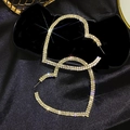 Exaggerated gold heart hoop earrings with sparkling rhinestones on black silk background - Gold
