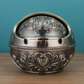 Spherical bronze metal ashtray with embossed roses and a lid on a wooden table - Bronze Large Rose Relief