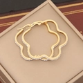 Dettaglio di orecchini a lobo dorati a fiore con cristalli su portagioie elegante - Stile Floreale