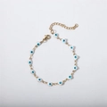 Dettaglio dei ciondoli a cuore portafortuna in oro con smalto blu e bianco su bracciale - Bianco