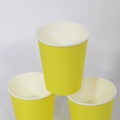 Three yellow disposable paper cups stacked in a pyramid shape on a clean white background - 10 Pieces Pack / Yellow