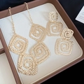 Detail of golden square spiral jewelry set with hammered texture in a beige gift box - Silver Jewelry Set