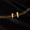 Asymmetric golden stainless steel cat stud earrings displayed on a rustic branch - 756 Gold