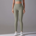 Close-up of high-waist seamless yoga leggings in sage green with tummy control compression - Carbon Dust