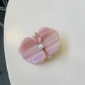 Detailed view of a pink petal hair clip with a white pearl on a clean surface - Pink Orchid