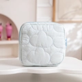 Close-up of light blue cloud-quilted fabric storage bag with color-matched zipper - Blue