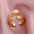 Macro di anello a teschio dorato con texture gotica su superficie di seta rosa liscio - Aperto Regolabile / Stile teschio KC Oro (A-677)
