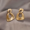 Eleganti orecchini pendenti geometrici in oro opaco su lussuoso tessuto di seta - Geometria Incastrata (26) / Oro Opaco