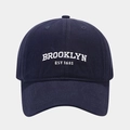 Close-up of white Brooklyn EST 1631 embroidery on a premium navy blue cotton baseball cap - Adjustable / Navy Blue