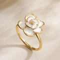 Macro shot of 18K gold plated ring featuring a white enamel camellia and pearl center - Camellia (14537)