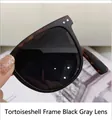 Gafas de sol plegables con montura de carey y lentes gris oscuro sobre una revista - Carey (1ª Generación)
