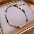 Détail d'un bracelet de perles colorées avec séparateurs dorés et fermoir mousqueton - Style de Perles Plaqué Or 18K