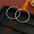Close-up of silver hoop earrings with polished mirror finish on black leather texture - 8# 40mm Smooth Silver Large Hoop Earrings (Silver Earring Post)