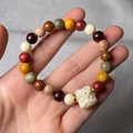 Close-up of multicolor wooden beads bracelet with a carved white lion charm detail - Multi-colored Beads Lion Charm (8mm*22 Beads)