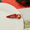 Cute red Christmas stocking hair clip with bell and green bow on white plate - Red Christmas Sock Hair Clip