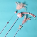 Pink and white feather cat wand set with bells and plush balls on blue background - 3-Piece Cat Teaser Wand Set Pink