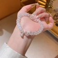 Dettaglio del bracciale di perle di cristallo con ciondoli a forma di loto e campanella - Bracciale-Bianco (HB4069)