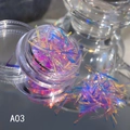 Vista macro di scaglie per nail art aurora A03 in barattolo su superficie a specchio - A-03 (Paillettes Aurora/Frammenti)
