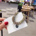 Élastique à perles gris transparent avec cordon doré et breloque en métal ronde - Gris