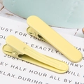 Detail of two matte yellow metal hair clips on a minimalist white card and blue background - 1.3x4.9cm / Light Yellow