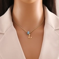 Detailed view of gold twisted chain with letter L pendant and blue evil eye charm - Letter L (N1339)