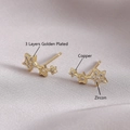 Elegant gold plated triple star stud earrings with zircon stones on silk background - Star Style