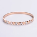 Vista detallada de incrustaciones de nácar en forma de corazón en pulsera rosa - Oro rosa