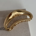 Detail of large golden crescent hollow metal hair claw clip on textured linen bag - Mirror Polishing / Bright Gold