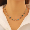 Nahaufnahme einer Vintage-Goldkette mit bunten geometrischen Edelsteinen am Model - Goldener Mehrfarbiger Retro-Geometrischer Stil (A-91)