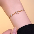 Elegante bracciale dorato con fiocco, stelle e zirconi indossato al polso di una modella - Oro (S1102)