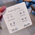 Close-up of a silver 6-pair stud earring set for a week held on a branded fashion card - E1536-1 Butterfly Heart Starfish Style