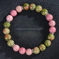 Macro shot of sunstone and rose quartz fertility bracelet on black leather backdrop - Pink and Green Unakite (Fertility-B)