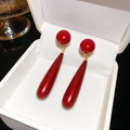 Dettaglio di orecchini pendenti a goccia rossi con perni dorati in una confezione - Resina / Lega / Rosso Retrò / Rosso