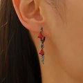 Close-up of gothic red rhombus gem earrings with metal leaf pendant on model - Gun Black Red Zirconia Feather Single (A-550)