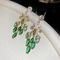 Macro shot of gold tassel earrings featuring green emerald-cut stones and sparkling crystals - Court Tassel Style (23#)