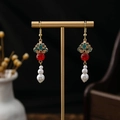 Detail of vintage Chinese earrings with red beads and pearls on a gold display stand - Gold Red White Triple Beaded
