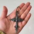 Ciondolo a croce gotica vintage con dettagli in rilievo tenuto in mano per scala - Portachiavi