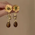 Dettaglio macro di orecchini vintage a fiori con strass verdi e pietre marroni lucide - 1# Oro - Nappa Fiore (Perno in Argento)
