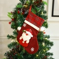 Classic red Christmas stocking with 3D Santa applique and plaid trim on a Christmas tree - Santa Claus