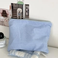 Detailed view of sky blue checkered cotton pouch with zipper in a lifestyle setting - Blue