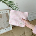 Gros plan sur la trousse de toilette à carreaux roses avec tissu texturé et logo - Rose